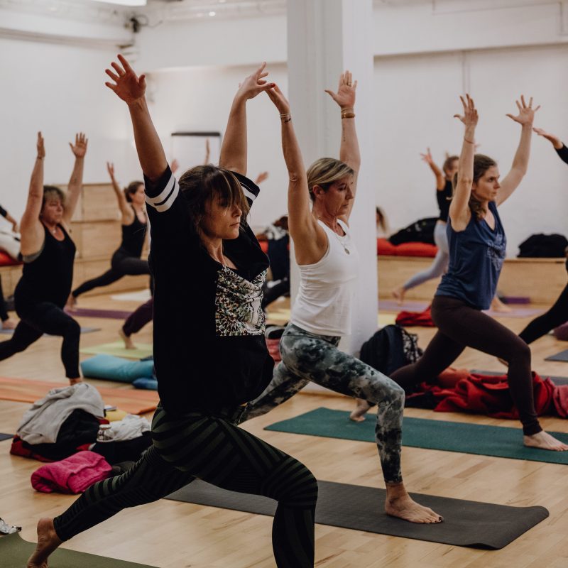 yogaschueler ueben yoga im yogastudio arme nach oben